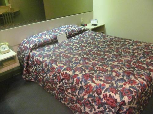 a bedroom with a bed with a colorful comforter at Microtel Inn by Wyndham Champaign in Champaign