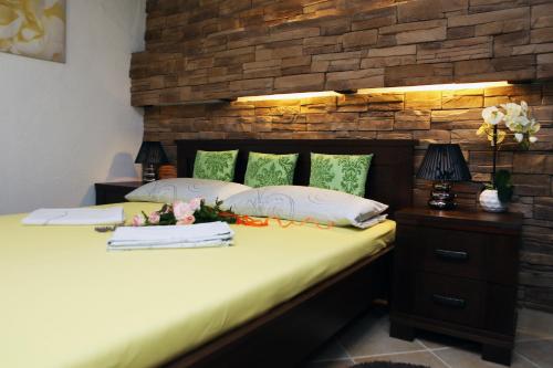 a bedroom with a bed with a brick wall at Apartments Vila ViDa Orebić in Orebić