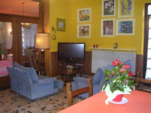 a living room with blue chairs and a television at Albergo San Cristoforo in Pergine Valsugana