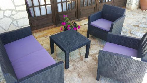 a group of chairs and tables with purple cushions at Louro's Villa - 12130AL in Cantanhede