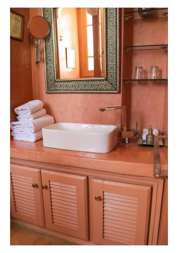 a bathroom with a sink and a mirror and towels at La Maison de Tanger in Tangier