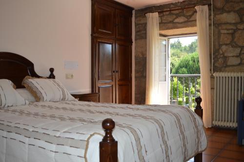 a bedroom with a bed and a large window at Casa Loureiro in Caldas de Reis