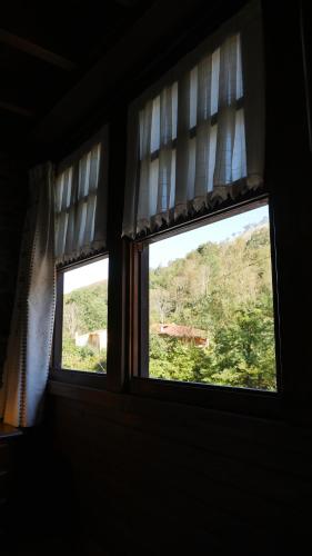 two windows in a room with a view at Hotel Rural Los Texos in La Riera