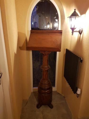 a wooden table in a hallway next to a lamp at Renovated Church close to the beach in Llanelli