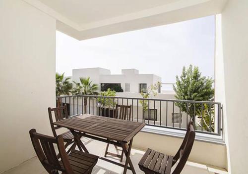 マルベーリャにあるSamara Marbella Apartmentの木製テーブルと椅子2脚付きのバルコニー