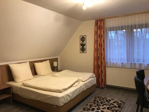 a small bedroom with a bed and a window at Apartment-Pension Schwalbennest in Herzogenaurach
