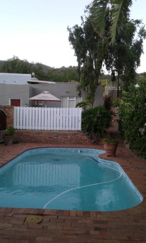 a swimming pool in a yard with a white fence at @Echeveria in Montagu