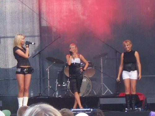 three women singing on a stage with a microphone at Domwigierski pl -Jeziorki -GR- Comfort-Ferienhaus-Polen - własna linia brzegowa i sauna in Wysoki Most