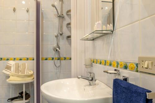 a white bathroom with a sink and a shower at Casa Martina in Giardini Naxos