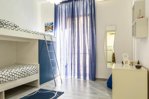 a bedroom with a bunk bed and a ladder next to a window at Casa Martina in Giardini Naxos