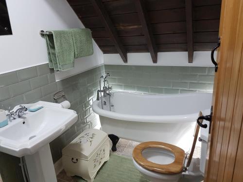 a bathroom with a sink and a toilet and a tub at Renovated Church close to the beach in Llanelli