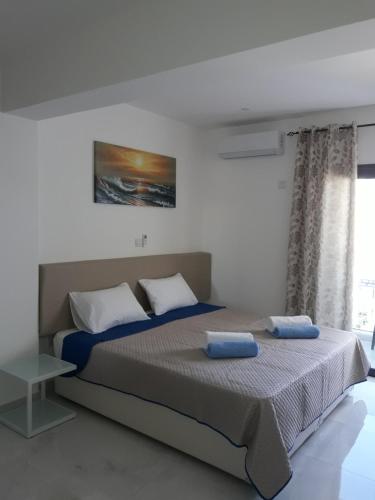 a bedroom with a large bed with blue pillows at P.L Hermes Studios & Apartments in Larnaka