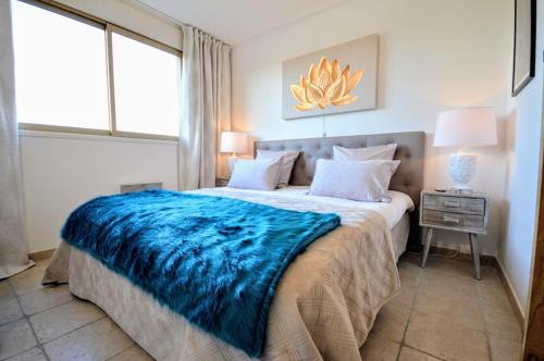 une chambre avec un grand lit avec une couverture bleue dans l'établissement Saint Tropez Sea View Penthouse, à Saint-Tropez