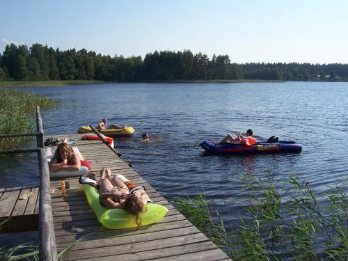 a group of people rafting on a dock on a lake at Domwigierski pl -Jeziorki -GR- Comfort-Ferienhaus-Polen - własna linia brzegowa i sauna in Wysoki Most