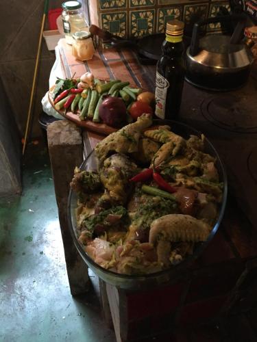 a large pan of food on a table with vegetables at Delirius Hospedagem in Itamonte