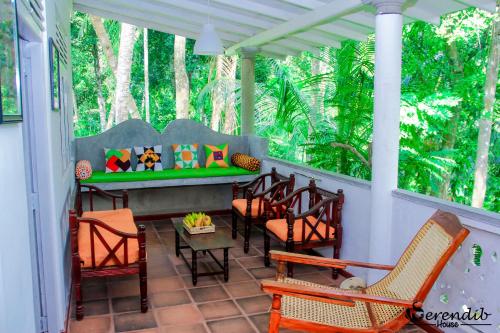 a porch with chairs and a bench on it at Serendib House in Unawatuna