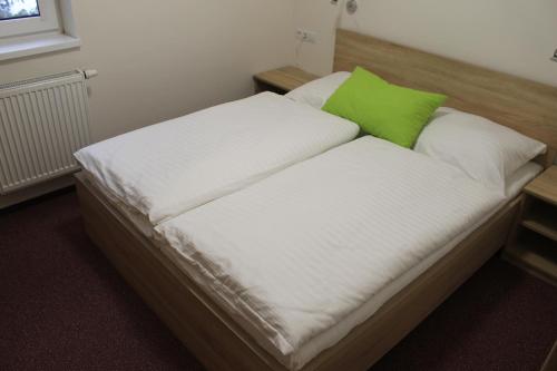 a bed with a green pillow on top of it at Apartment Lúčky - Jasná in Demanovska Dolina