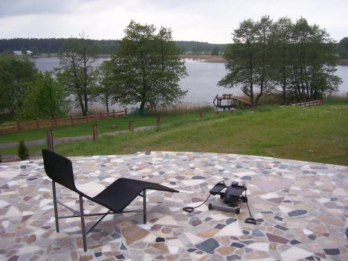 a chair sitting on a stone floor with a camera at Domwigierski pl -Jeziorki -GR- Comfort-Ferienhaus-Polen - własna linia brzegowa i sauna in Wysoki Most