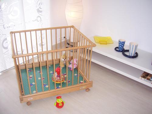 a crib with some toys in it in a room at Domwigierski pl -Jeziorki -GR- Comfort-Ferienhaus-Polen - własna linia brzegowa i sauna in Wysoki Most