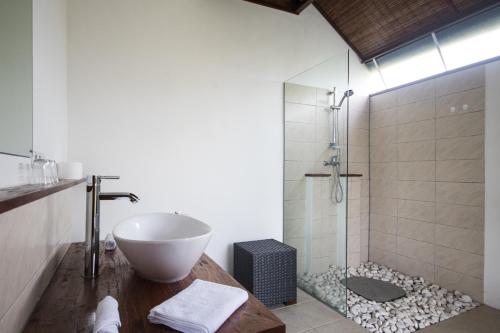 y baño con lavabo y ducha. en Medewi Snaffl Beach Villa, en Pulukan