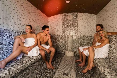 a group of people sitting in a sauna at Rezort Gothal Apartmány a Penzióny in Donovaly