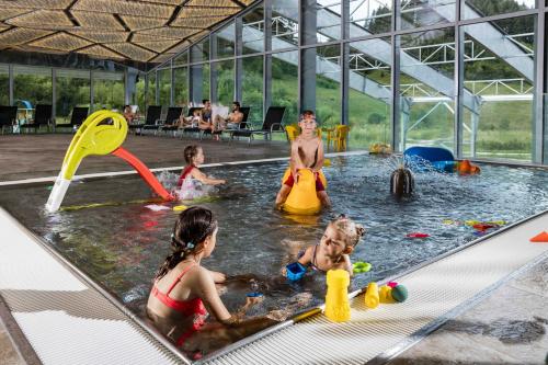 a group of children playing in an indoor swimming pool at Rezort Gothal Apartmány a Penzióny in Donovaly