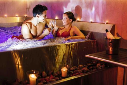 a man and a woman sitting in a bathtub at Rezort Gothal Apartmány a Penzióny in Donovaly