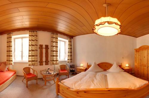 ein Schlafzimmer mit einem großen Bett und einer Holzdecke in der Unterkunft Hotel Weingut Schützen in Senheim