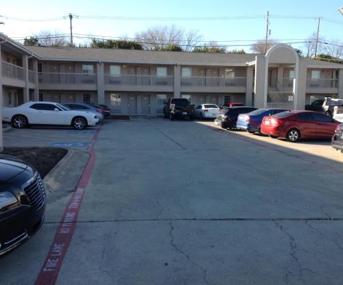 a parking lot with cars parked in front of a building at Heights Inn in Harker Heights