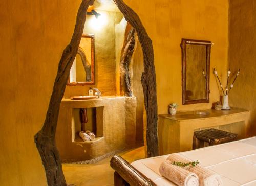 ein Bad mit einem Waschbecken und einem Spiegel in der Unterkunft Little Bush Lodge in Hoedspruit