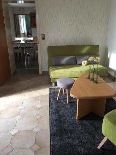 a living room with a green couch and a table at Historical Apartment in Gummersbach