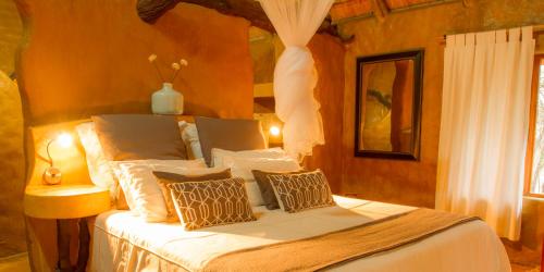 a bedroom with a bed with white sheets and pillows at LittleBush Private Lodge in Hoedspruit