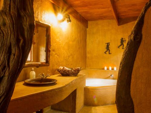a bathroom with a tub and a sink and a bath tub at LittleBush Private Lodge in Hoedspruit