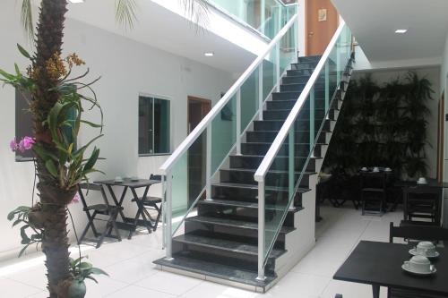 a staircase in a restaurant with tables and chairs at Pousada Orquideas de Maria in Aparecida