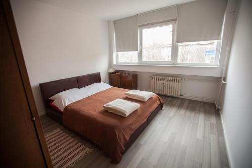 um quarto com uma cama com duas toalhas em RiverView apartment em Osijek