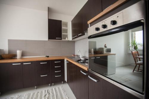 uma cozinha com armários de madeira e um forno com placa de fogão em RiverView apartment em Osijek