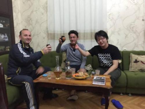 a group of three men sitting around a coffee table at Giorgi's Homestay in Kutaisi