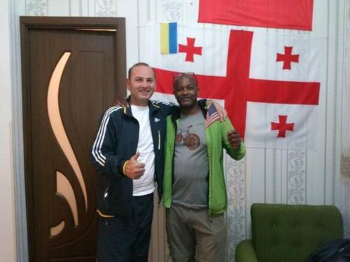 two men standing next to each other in front of a flag at Giorgi's Homestay in Kutaisi