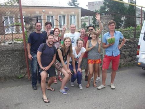a group of people posing in front of a fence at Giorgi's Homestay in Kutaisi