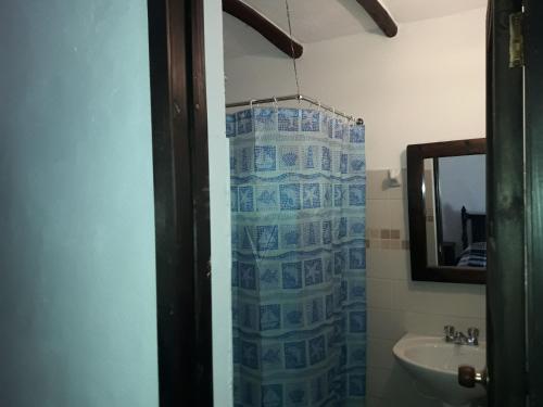 a bathroom with a shower curtain and a sink at Casa Campestre SUANOGA in Pesca
