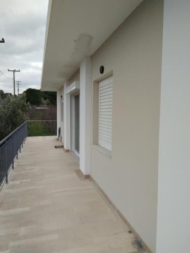 a balcony with a white wall and a window at Dimitri's house in Dhílesi