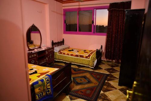 a living room with two beds and a mirror at Taha Guest House in Aswan