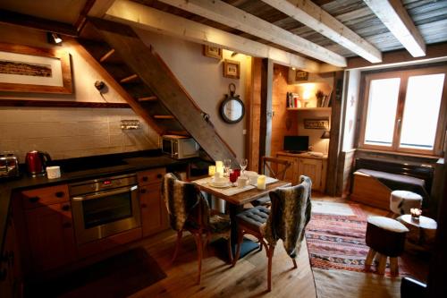 - une cuisine avec une table, des chaises et une cuisinière dans l'établissement Duplex en vieux bois hyper centre, à Chamonix-Mont-Blanc
