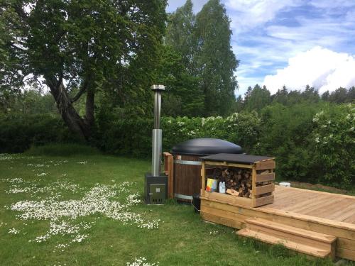 a wooden deck with a wood stove in a yard at Sättraby villa in Norrtälje