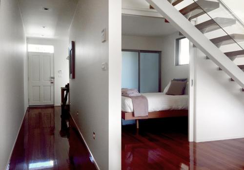a bedroom with a bed and a stair case at Sullivans Cove Apartments in Hobart