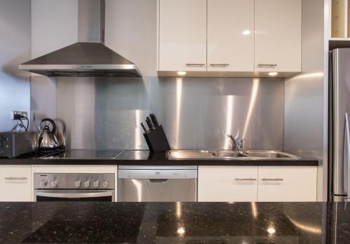 a kitchen with a sink and a stove at Sullivans Cove Apartments in Hobart