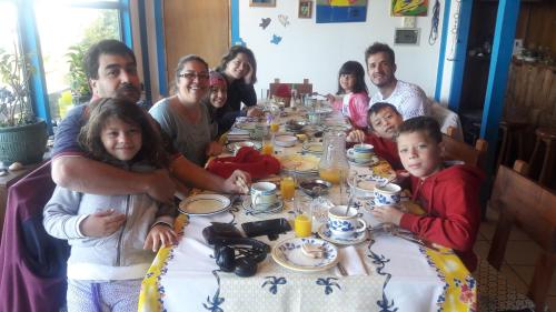 a group of people sitting at a dinner table at Hostal y Cabañas Mozart in Puerto Montt