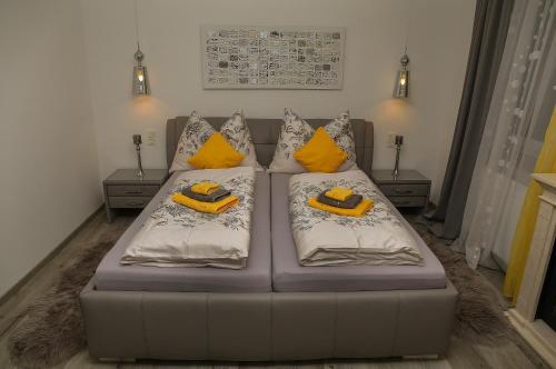 a living room with a couch with yellow pillows at Pension & Restaurant La Amalia in Bad Sauerbrunn