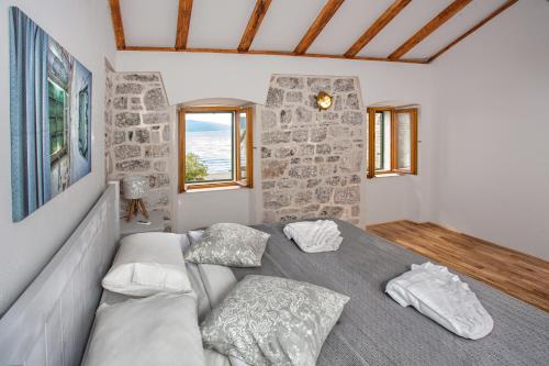 ein Zimmer mit einem Bett mit Kissen darauf in der Unterkunft Villa Ruza, Donja Lastva in Tivat