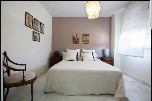 ロケタス・デ・マルにあるPlaya Serena Mar y Golf gran terrazaのベッドルーム(白いベッド1台、椅子付)